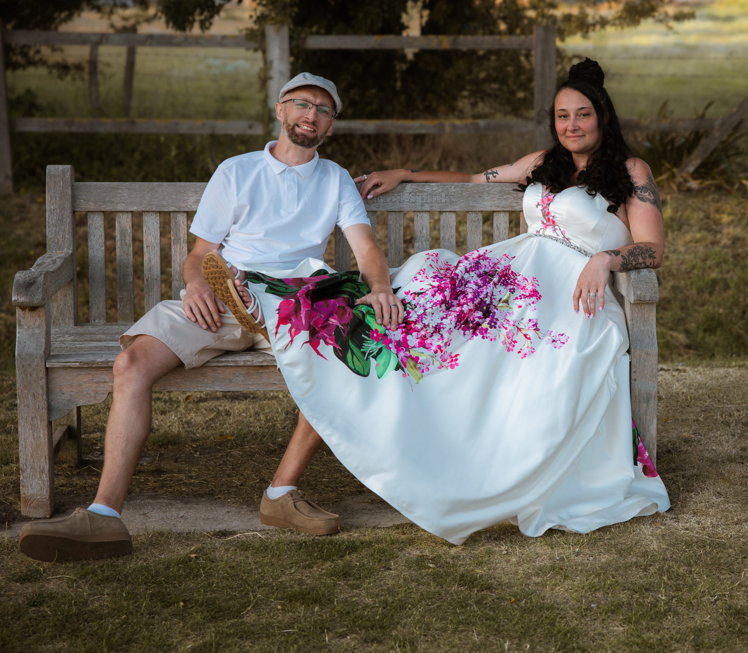 bride and groom sitting in a park